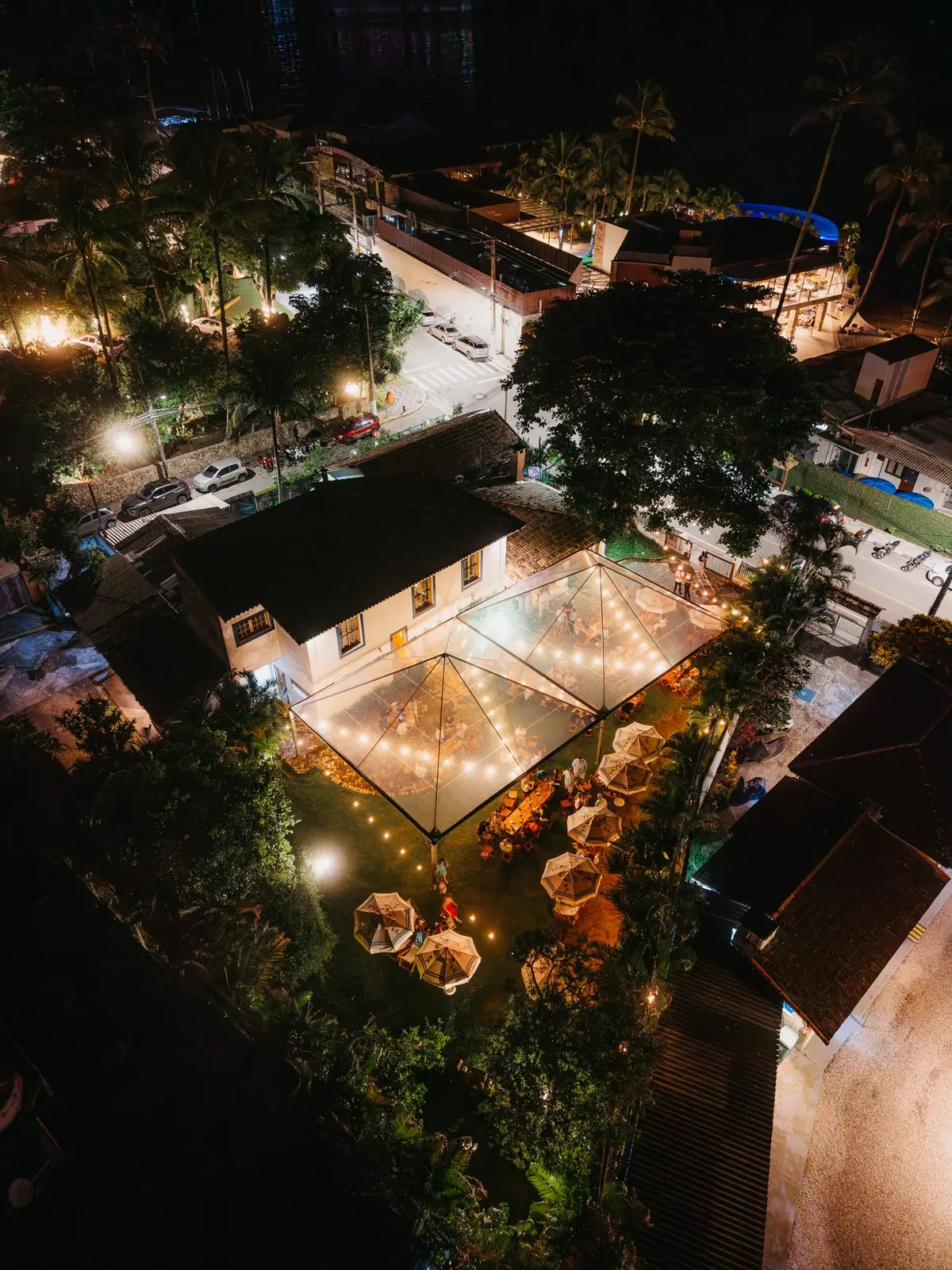 Vista aérea ampla da Garden à noite, com o toldo aceso no meio do casario do Centro Histórico.
